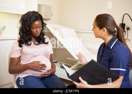 Donna incinta essendo dato Ante Natal controllare da un infermiere Foto Stock