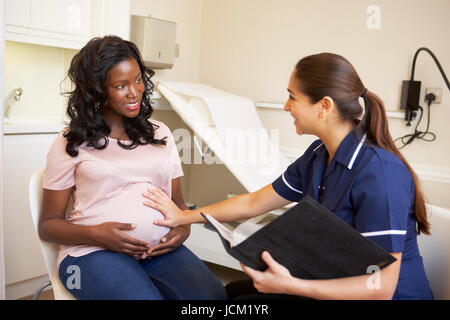 Donna incinta essendo dato Ante Natal controllare da un infermiere Foto Stock