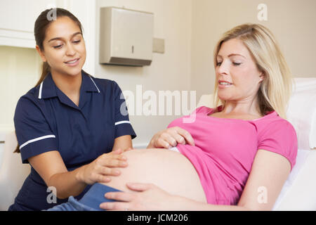 Donna incinta essendo dato Ante Natal controllare da un infermiere Foto Stock