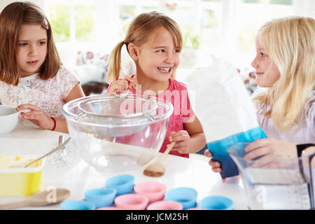 Le tre ragazze rendendo i tortini in cucina Foto Stock