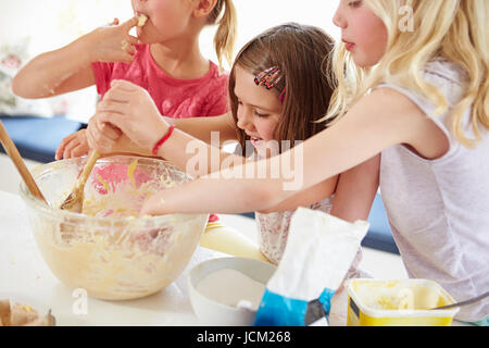 Le tre ragazze rendendo i tortini in cucina Foto Stock