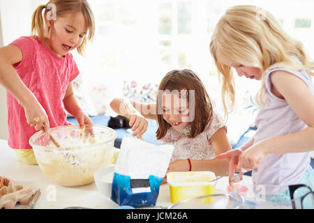 Le tre ragazze rendendo i tortini in cucina Foto Stock