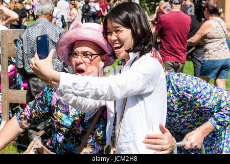 Inghilterra, Coxheath. La crema mondiale campionati del grafico a torta. Ridere ragazza giapponese tenendo selfie con uno dei Grannie della squadra, Uomini vestiti come old ladies. Foto Stock