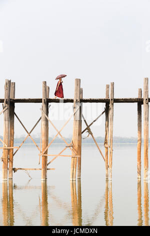 Monaco attraversando U Bein bridge, Amarapura Taungmyo del lago, Mandalay regione, Myanmar Foto Stock