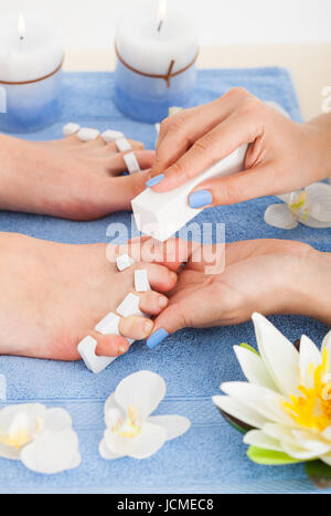 Immagine ritagliata di deposito pedicurist toenails della donna nel salone di bellezza Foto Stock