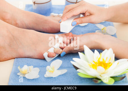 Immagine ritagliata di deposito pedicurist toenails della donna nel salone di bellezza Foto Stock