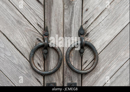 Vintage in legno scuro porte rotonde con maniglie di metallo in forma di anelli. Sfondo. Il telaio orizzontale. Foto Stock