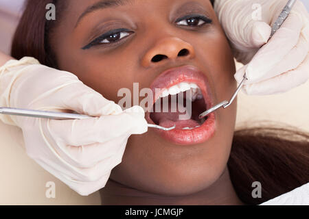 Vista dettagliata del paziente femmina essendo controllato dal dentista in clinica Foto Stock