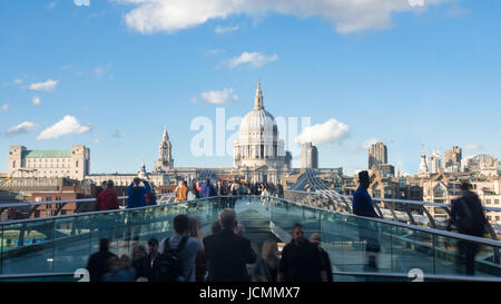 Vista del Millennium Bridge di Londra con la cattedrale di St Paul e turisti e pendolari a piedi Foto Stock