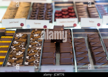 Tartufi di cioccolato, caramelle e dolci store sulla vetrina nella factory store. Il cioccolato di dimensioni di bit per la vendita nel locale del negozio di cioccolato. Foto Stock