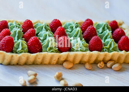 Crostata di pistacchio. Il pistacchio tart su bianco cioccolato Belga BARRY con uno strato di confettura di lamponi confit, croccante a base di pasta frolla e crema di fading e succosa raspb Foto Stock