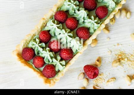 Crostata di pistacchio. Il pistacchio tart su bianco cioccolato Belga BARRY con uno strato di confettura di lamponi confit, croccante a base di pasta frolla e crema di fading e succosa raspb Foto Stock