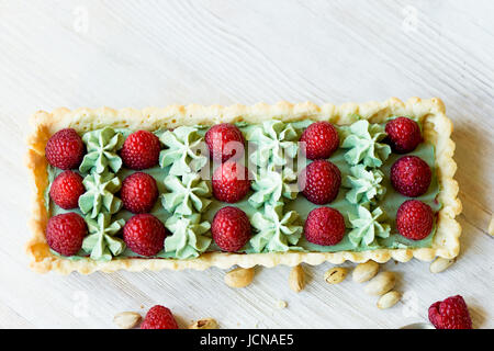 Crostata di pistacchio. Il pistacchio tart su bianco cioccolato Belga BARRY con uno strato di confettura di lamponi confit, croccante a base di pasta frolla e crema di fading e succosa raspb Foto Stock