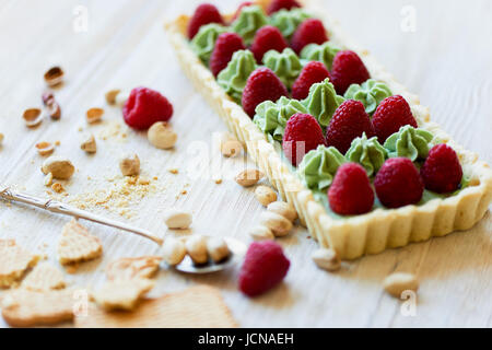 Crostata di pistacchio. Il pistacchio tart su bianco cioccolato Belga BARRY con uno strato di confettura di lamponi confit, croccante a base di pasta frolla e crema di fading e succosa raspb Foto Stock