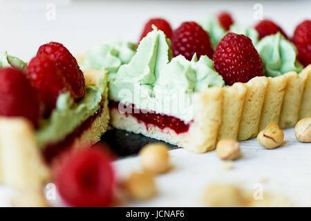 Crostata di pistacchio. Il pistacchio tart su bianco cioccolato Belga BARRY con uno strato di confettura di lamponi confit, croccante a base di pasta frolla e crema di fading e succosa raspb Foto Stock