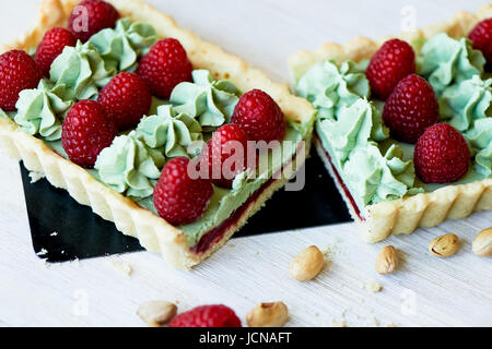 Crostata di pistacchio. Il pistacchio tart su bianco cioccolato Belga BARRY con uno strato di confettura di lamponi confit, croccante a base di pasta frolla e crema di fading e succosa raspb Foto Stock