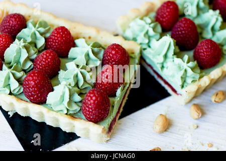 Crostata di pistacchio. Il pistacchio tart su bianco cioccolato Belga BARRY con uno strato di confettura di lamponi confit, croccante a base di pasta frolla e crema di fading e succosa raspb Foto Stock