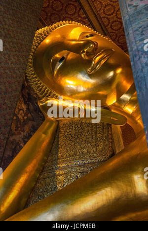 La foglia oro volto coperto e il braccio del Buddha di posa in Wat Pho, Bangkok, Thailandia. Foto Stock