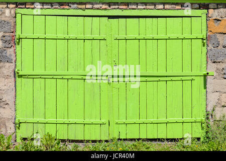 Garage facciata con vecchi cancelli verdi. Vecchia porta del garage Foto Stock