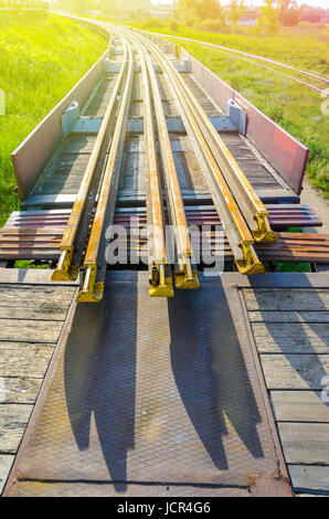 Elementi del fungo della rotaia. Trasporto di lungo rotaie di nuovo su di un carro merci. Percorso ad anello chiuso. Il gioco di guida. Carico speciale. Foto Stock