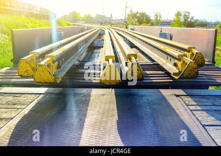 Elementi del fungo della rotaia. Trasporto di lungo rotaie di nuovo su di un carro merci. Percorso ad anello chiuso. Il gioco di guida. Carico speciale. Foto Stock