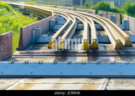 Elementi del fungo della rotaia. Trasporto di lungo rotaie di nuovo su di un carro merci. Percorso ad anello chiuso. Il gioco di guida. Carico speciale. Foto Stock