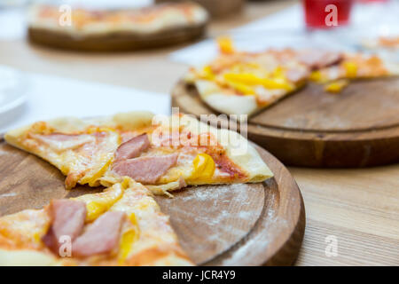 Pizza Fresca su un supporto in legno closeup Foto Stock