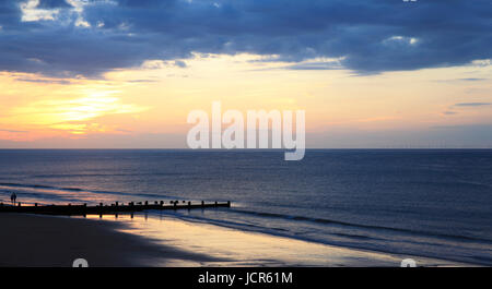 Il sole tramonta oltre il mare del Nord e Cromer Beach, Cromer, Norfolk, Inghilterra, Europa Foto Stock