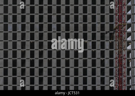 La texture del frammento di un moderno Ferro-parete in cemento con finestre senza vetri. Facciata di nuovi edifici a più piani. Architettura di edificio dallo stile moderno. Foto Stock