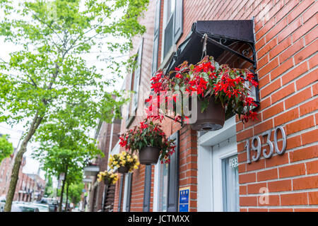 Montreal, Canada - 26 Maggio 2017: appendere rosso fioriere sulla costruzione di mattoni in area urbana Foto Stock