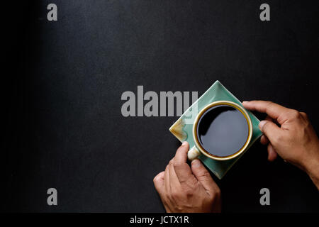 Vista da sopra con copyspace di uomo mani tenendo il caffè sul tavolo da cucina. Hero concetto della testata con copia spazio. Foto Stock