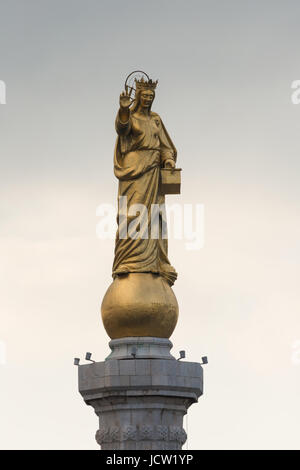 Statua dorata della Madonna della Lettera (Madonna della Lettera) sulla parte superiore della colonna a Porto entrata al porto della città di Messina, Sicilia, Italia Foto Stock