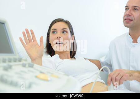 Medico facendo ultrasuoni sul ventre della donna incinta in clinica Foto Stock