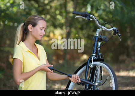 Ragazza pompe fino pneumatici di biciclette Foto Stock