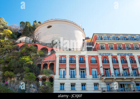 Nizza, Francia - 19 Marzo 2016: un hotel sul lungomare con la collina del castello in background Foto Stock