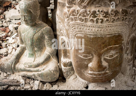 Pietra di Buddha scolpita e testa di Khmer come visto presso il tempio Bayon all'interno di Angkor Wat complesso di templi in Siem Reap, Cambogia Foto Stock