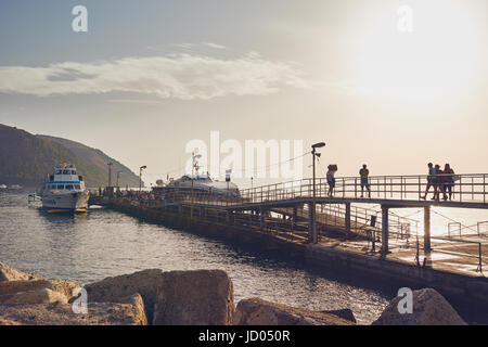 Isole Eolie o Lipari, Sicilia, Italia, Giugno 8 / 2016. Porto di Lipari, Porto al tramonto, i turisti a piedi sul molo. Foto Stock
