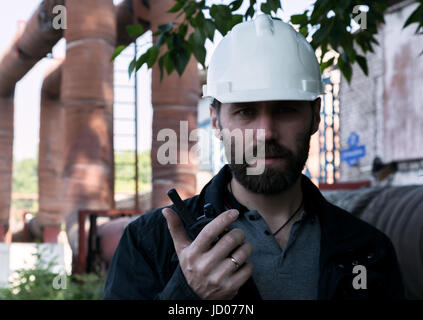 Ingegnere supervisore uomo azienda blueprint plan ed ispeziona la pipeline Foto Stock