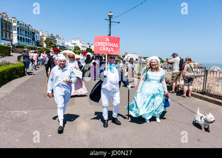 Inghilterra, Broadstairs. Dickens la settimana del Festival, la sfilata principale su Broadstairs fronte mare, con vari gruppi in costume Vittoriano. Personaggi di Dickens' libro, "A Christmas Carol, camminando verso il visualizzatore sul lungomare. Foto Stock