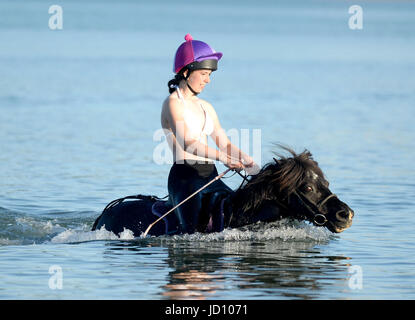 I piloti e i loro cavalli e pony rinfrescarvi dal weekend di calore nella Baia di Weymouth Dorset, UK Credit: Finnbarr Webster/Alamy Live News Foto Stock