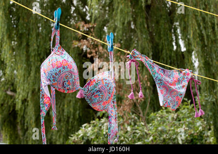 Un bikini colorati appesi su una linea di lavaggio Foto Stock