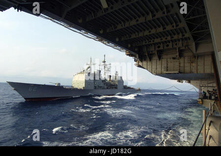 La Marina missile cruiser USS Chancellorsville (CG 62) si affianca la portaerei USS Kitty Hawk (CV 63) per il rifornimento in mare. DoD foto di Airman Joshua Wayne LeGrand, U.S. Navy Foto Stock