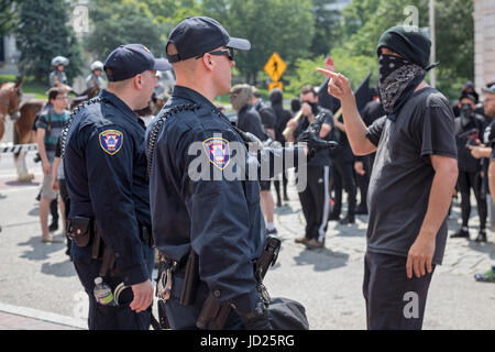 Harrisburg, Pennsylvania - un Black Bloc anarchico sostiene con la polizia durante il blocco di counter-dimostrazione contro un anti-musulmano, anti-sharia rally Foto Stock