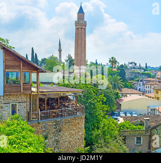 Il mattone rigati minareto della moschea Alaaddin sorge sopra i tetti del vecchio quartiere di Kaleici ad Antalya, Turchia. Foto Stock