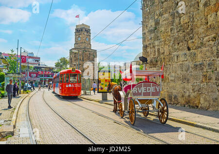 Antalya, Turchia - 6 maggio 2017: il tram e carrozze in cumhuriyet avenue accanto alla torre dell orologio (Saat Kulesi) e conservati i bastioni, il maggio Foto Stock