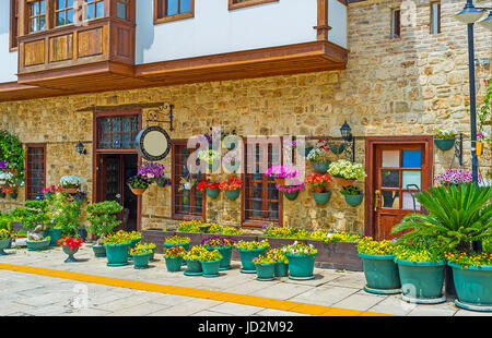 I numerosi vasi di fiori con colori luminosi e pansies nelle petunie ornano la facciata del vecchio edificio ottomano in Kaleici, Antalya, Turchia. Foto Stock