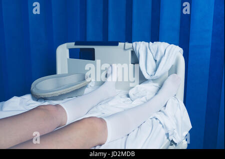 Le gambe di una donna indossare calze a compressione in un letto di ospedale Foto Stock