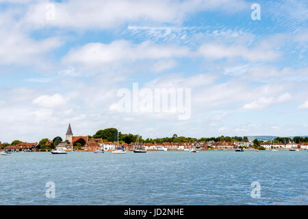 Chiesa della Santa Trinità e di edifici storici di Bosham, un villaggio costiero visto attraverso Chichester Porto sulla costa sud, West Sussex, in Inghilterra Foto Stock