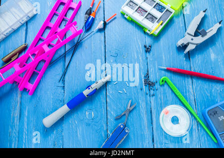 Gli accessori di pesca e strumenti su uno sfondo decorativo. Sfondo turchese. Foto Stock