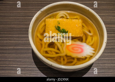 Kitsune Udon Noodle Giapponesi in bianco ciotola sul tavolo di legno vicino fino Foto Stock